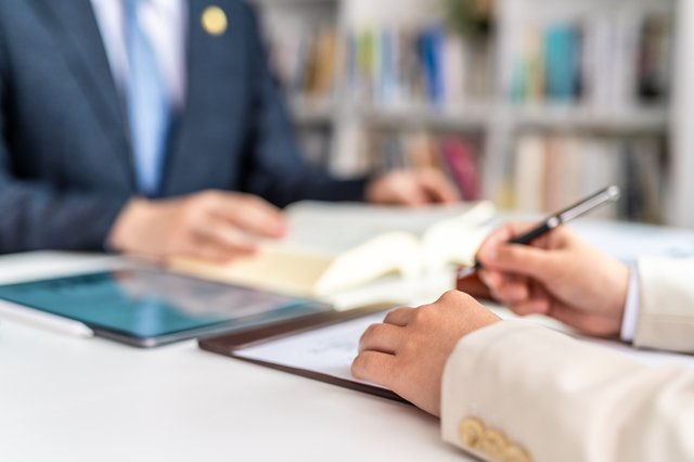 会議室のテーブルに契約書、ノートパソコン、法人印が並び企業法務の打ち合わせ準備が整った様子